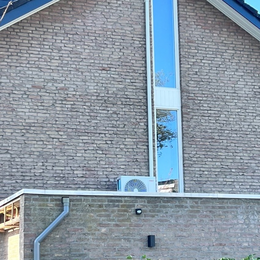 Puntgevel met een airco buitenunit op een lager plat dak
